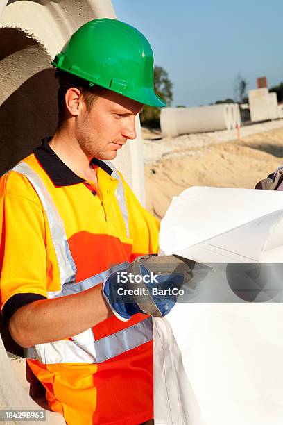 Manual Worker Busy With Road Construction Sewer On Background Stock Photo - Download Image Now