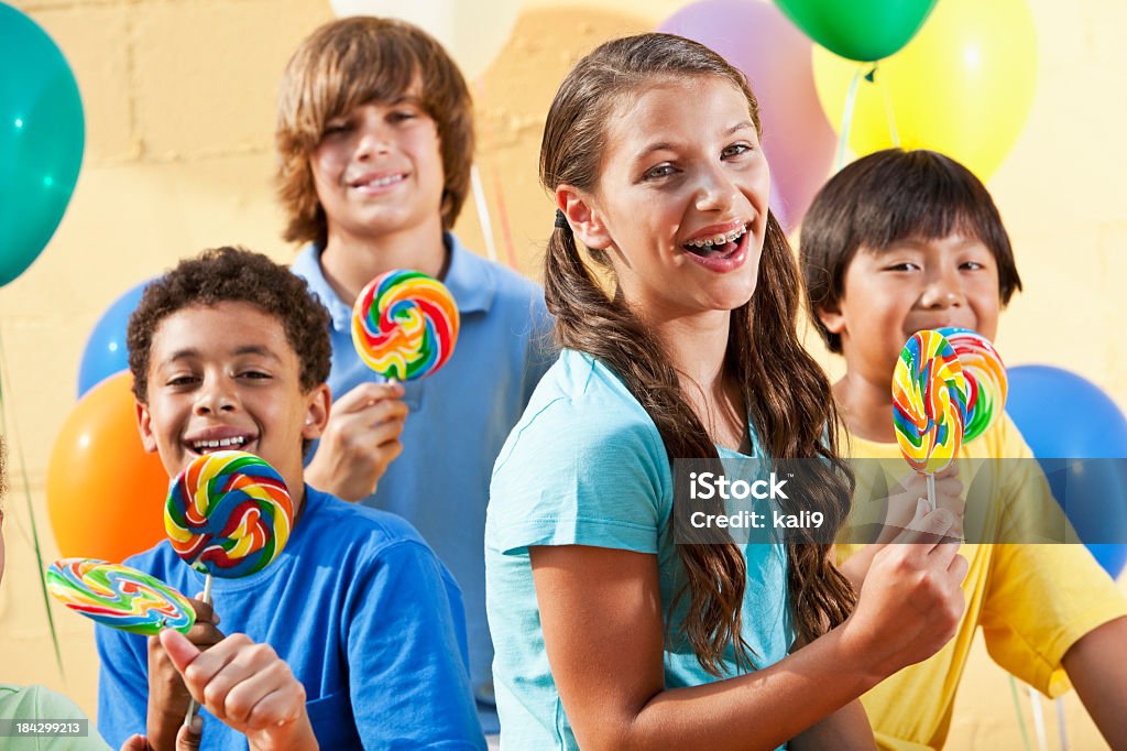 Children with lollipops and balloons Multiracial children at party with lollipops and balloons.  Focus on girl, 11 years. 10-11 Years Stock Photo