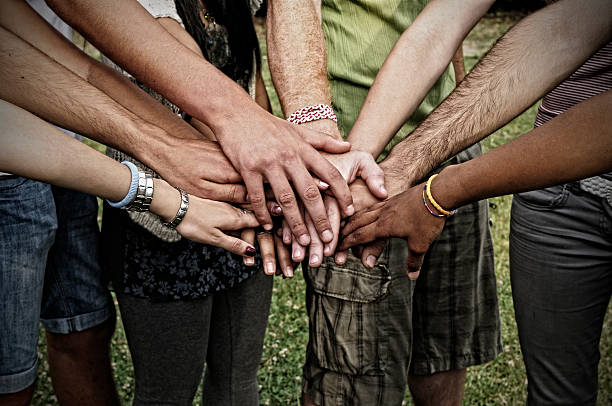 pila de hands.young personas de la unidad - human hand holding hands hands clasped group of people fotografías e imágenes de stock