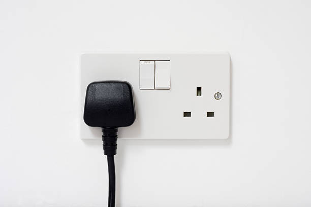 UK British electrical plug socket and plug on a wall UK plug socket and plug on a white wall three pin plug stock pictures, royalty-free photos & images