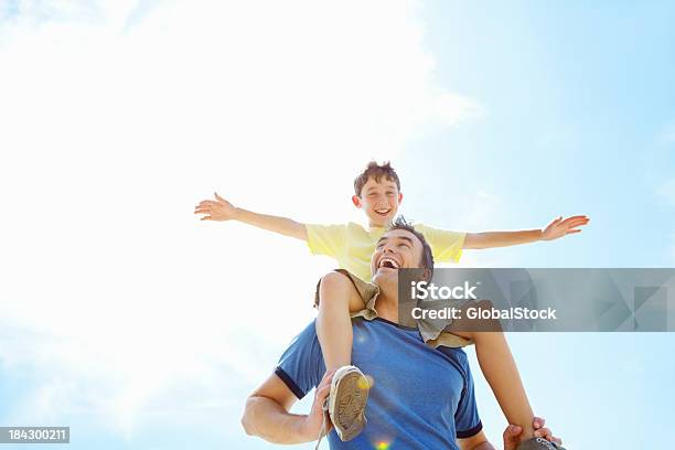 Son Having Fun Sitting On His Fathers Shoulders Stock Photo - Download Image Now - Carrying On Shoulders, Child, Sitting
