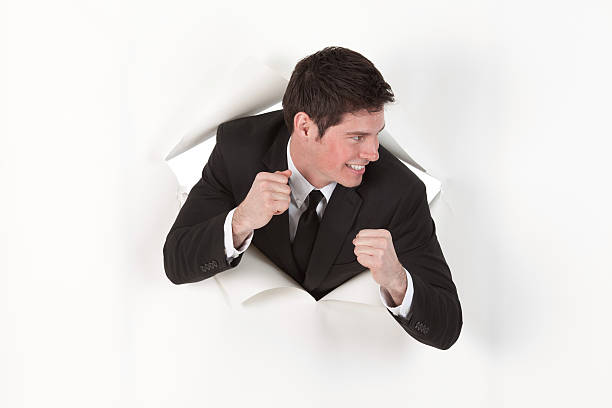 istock Businessman emerging through a hole in paper 184300540