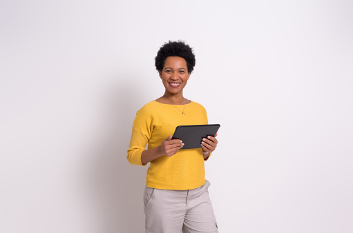 Portrait of female manager working over digital tablet and smiling at camera over white background