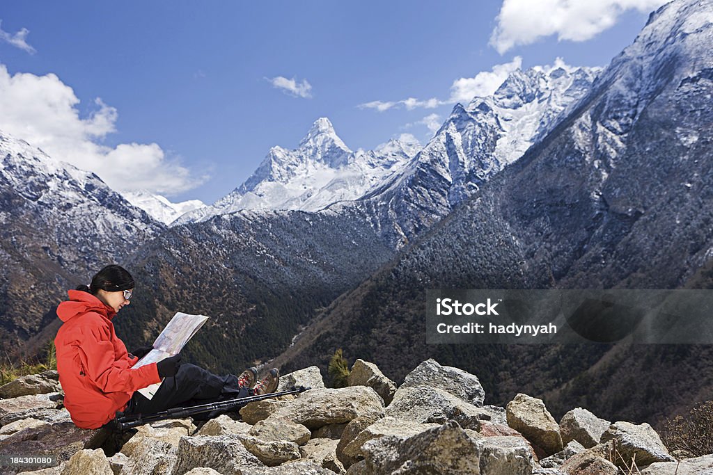 Donna seduta sulla roccia nel Parco Nazionale del monte Everest - Foto stock royalty-free di 20-24 anni