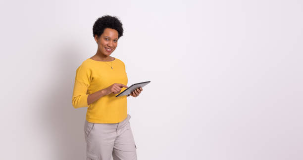 istock Confident female professional working on digital tablet while standing isolated on white background 1843011200
