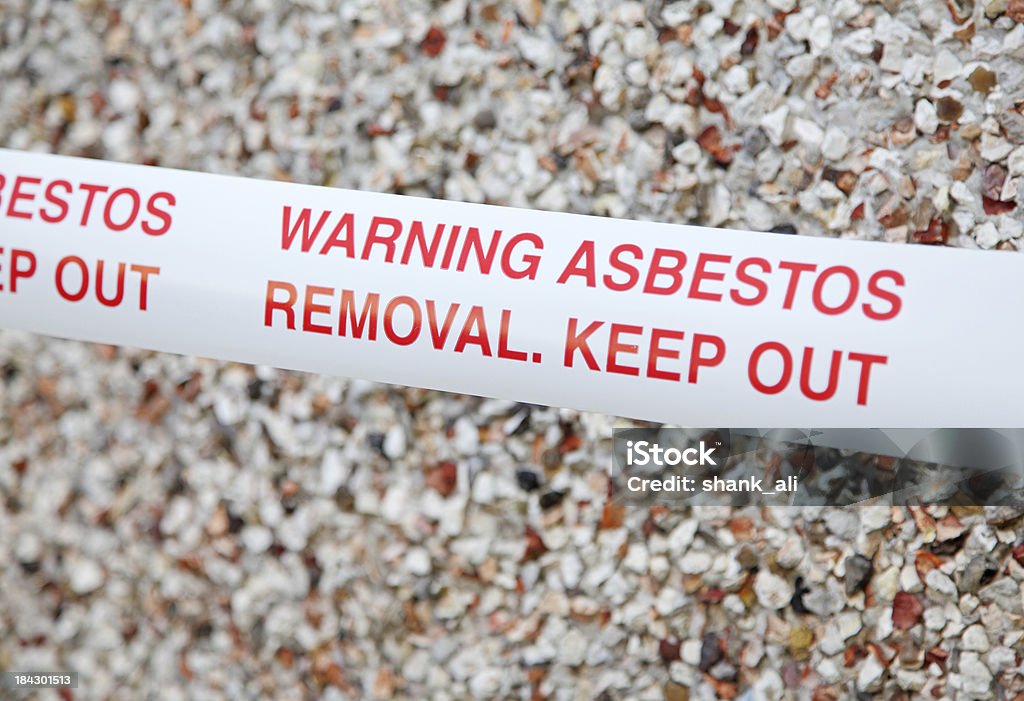 asbestos warning tape cordon tape outside a building containing the toxic waste-Asbestos.Please see some similar pictures from my portfolio: Asbestos Stock Photo