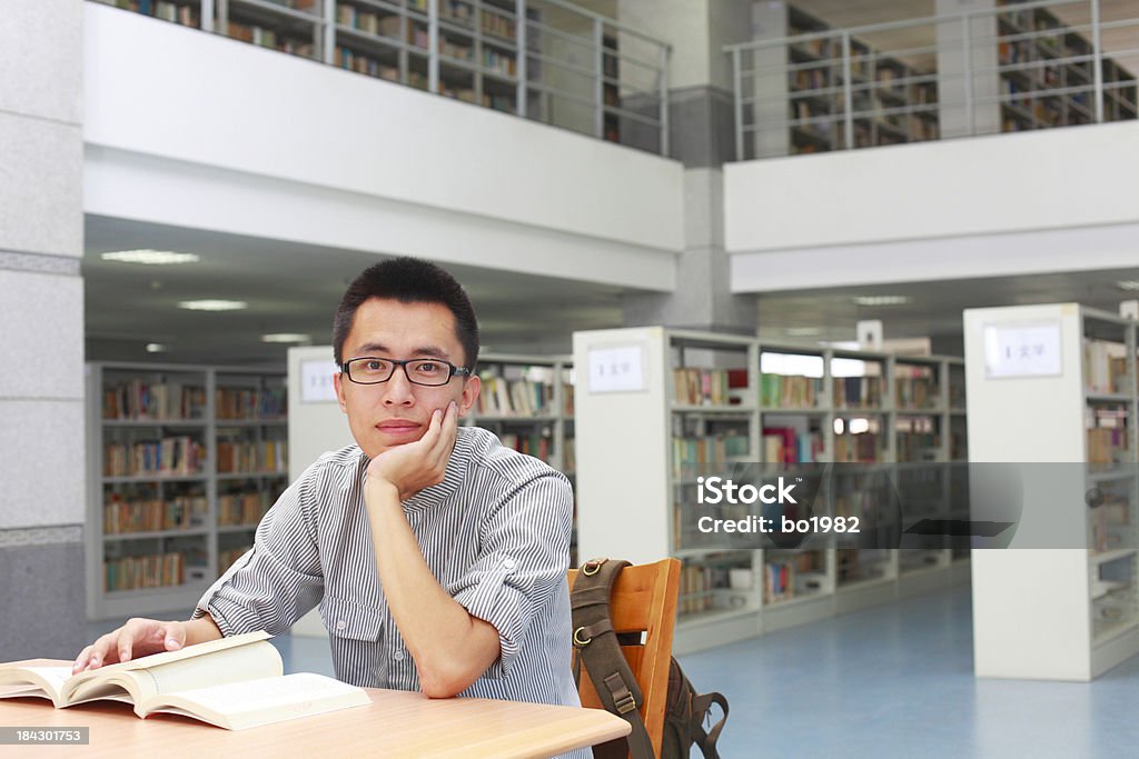 Retrato de um estudante universitário em uma biblioteca - Foto de stock de Estudante royalty-free