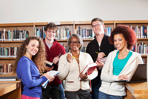 istock Teacher with high school students in library 184301813