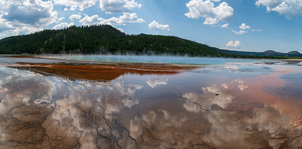 The Grand Prismatic Spring with awesome reflections of the clouds in Yellowstone national park during the summer