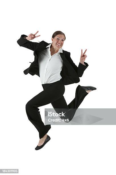 Businesswoman Jumping In Excitement Showing Victory Sign Stock Photo - Download Image Now