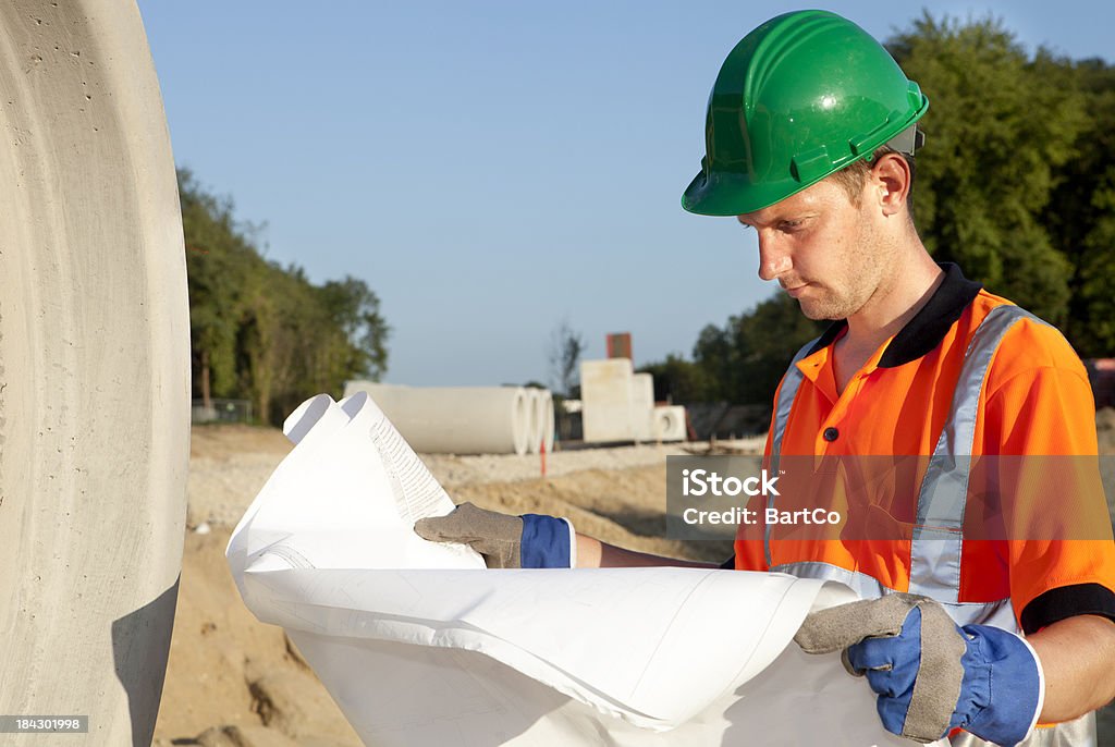 Trabalhador Manual ocupado com construção de estrada. Esgoto em plano de fundo. - Foto de stock de Construção de Estrada royalty-free