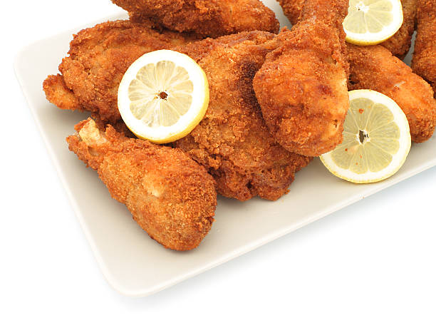 istock Homemade fried chicken legs on plate with lemons - diagonal 184302395