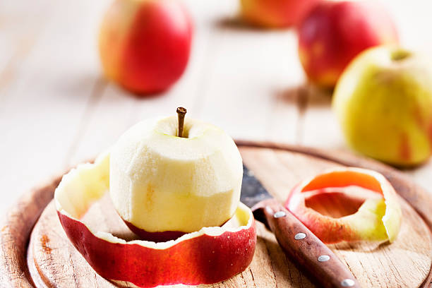 peeled apple peeled apple and kitchen knife on wooden cutting board peeling food stock pictures, royalty-free photos & images