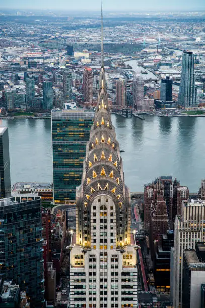Breathtaking drone view of modern skyscrapers near river in Manhattan district against cloudy blue in New York City with chrysler building