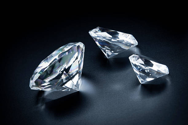 Three beautiful diamonds on a black background. "Photo of three various sizes diamonds scattered on black background. Beautiful, very expensive, precious stones." diamond shaped photos stock pictures, royalty-free photos & images