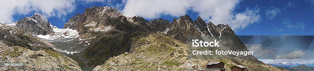 Alpine peaks mountain refuge panorama France "The dramatic rocky pinnacles of the Aiguille Rouges towering over the turquoise waters of Lac Blanc and the chalet refuge below panoramic Alpine skies, Chamonix, Haute-Savoie, France. ProPhoto RGB profile for maximum color fidelity and gamut." European Alps Stock Photo