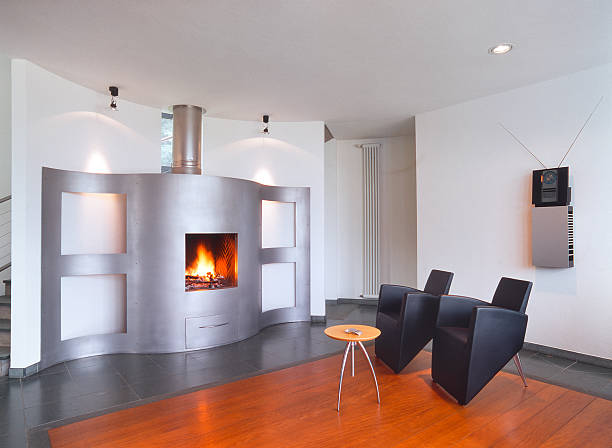 istock Modern living-room with curved fireplace and black leather chairs 184303617