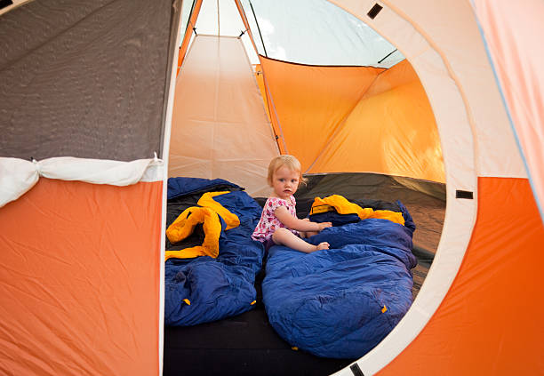 Little girl camping in a tent stock photo