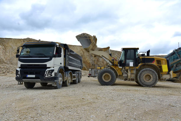 istock Yellow excavator loading stones in a truck 1843040000