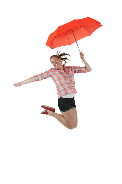 istock Woman holding an umbrella jumping in excitement 184304103