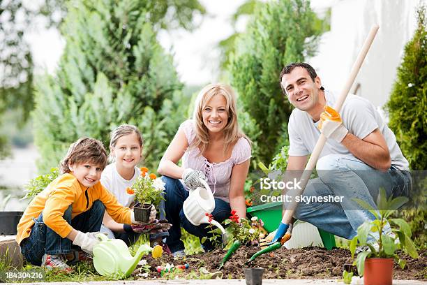 Ritratto Di Una Famiglia Di Giardinaggio - Fotografie stock e altre immagini di Piantare - Piantare, Albero, Bambino