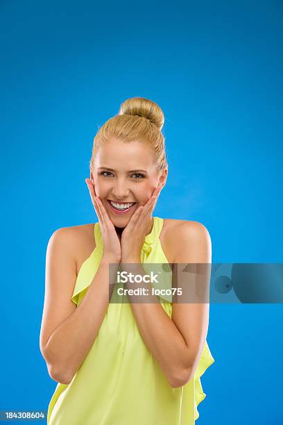 Młoda Kobieta Uśmiechając Się Z Rękami Na Podbródek Na Niebieskim Tle - zdjęcia stockowe i więcej obrazów 20-24 lata