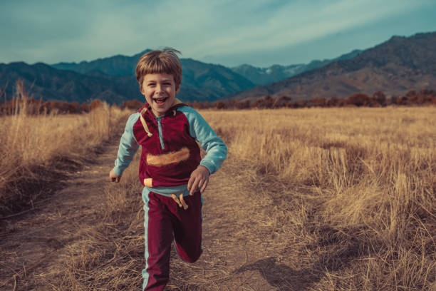 istock Child running on autumn field on mountains background 1843108952