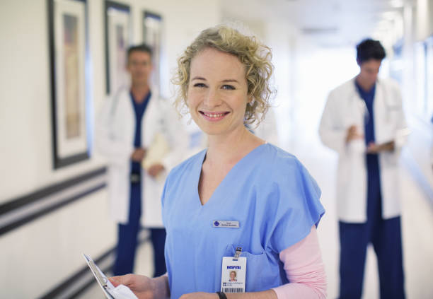 портрет улыбается медсестра в больнице коридор - female group of people male doctor стоковые фото и изображения
