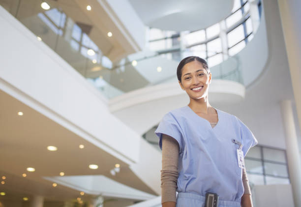 Portrait of smiling nurse in hospital atrium stock photo