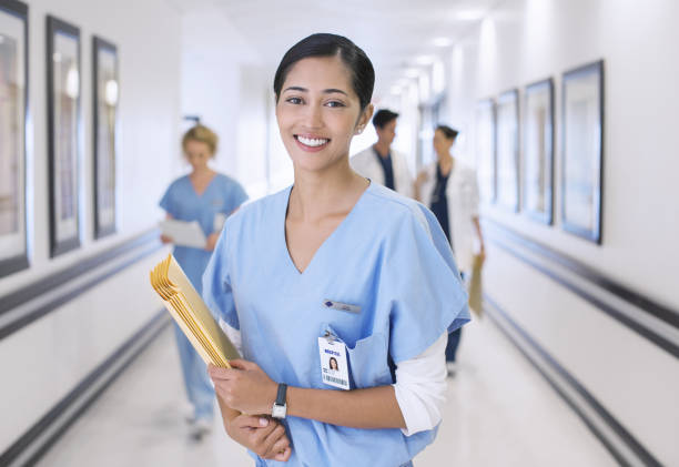 retrato de la sonriente enfermera en el hospital corredor - enfermero fotografías e imágenes de stock