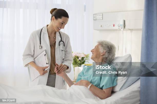 Doctor And Senior Patient Talking In Hospital Room Stock Photo - Download Image Now - Doctor, Patient, Hospital