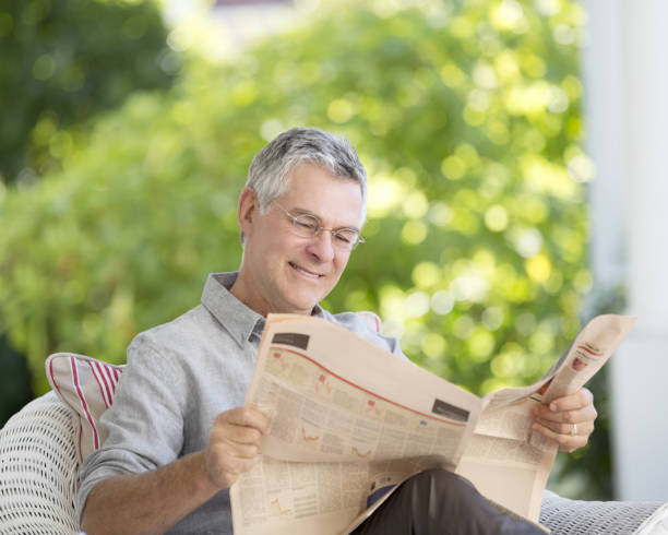 istock Senior man reading newspaper on patio 184312822