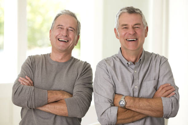 Portrait of senior men laughing with arms crossed stock photo