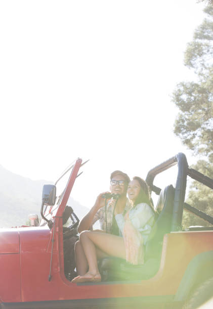 istock Couple using binoculars in sport utility vehicle 184312980