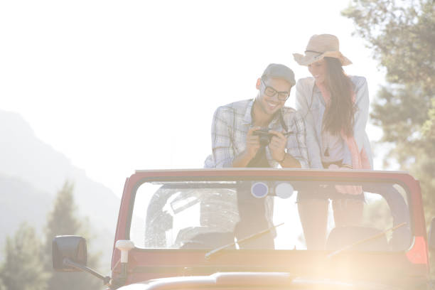 istock Couple with digital camera in sport utility vehicle 184312985
