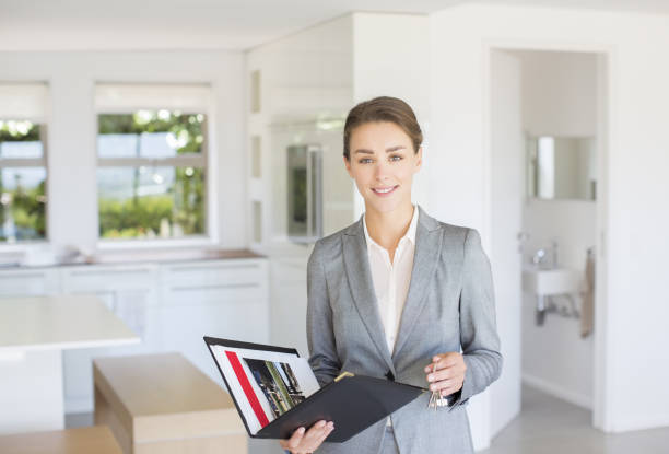 African American real estate agent communicating with a couple while showing them new house for sale.