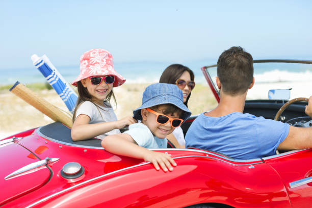 istock Family riding in convertible at beach 184313229
