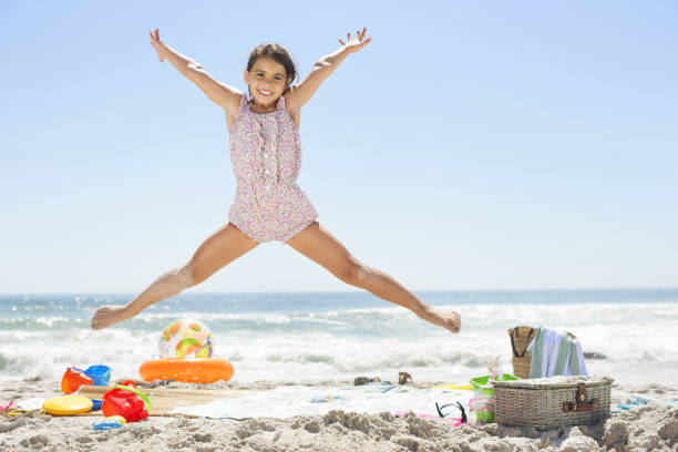 Girl jumping on beach  legs apart stock pictures, royalty-free photos & images