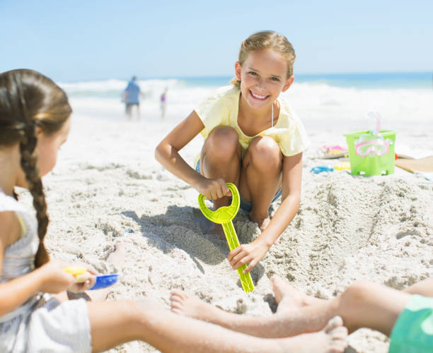 istock Girls digging in sand on beach 184313350