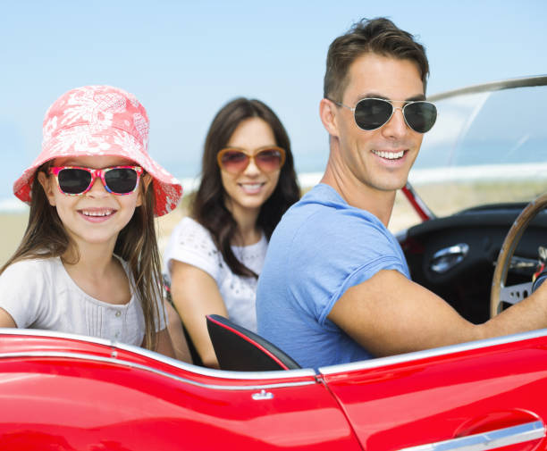 istock Family driving in convertible on beach 184313351