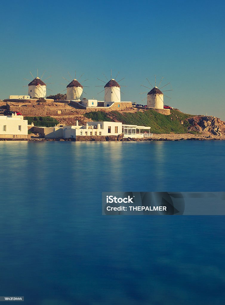 Mykonos windmills Mykonos island with its white traditional windmills on top of a hill reflecting on the calm bay water - Greece20 seconds long exposure with neutral density filter Aegean Sea Stock Photo