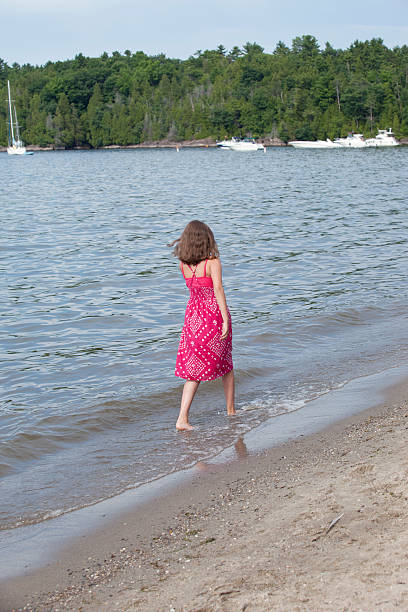 teen marchant sur la plage - wading child beach sundress photos et images de collection