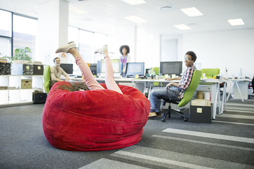 Empresaria jugando en beanbag silla de oficina photo