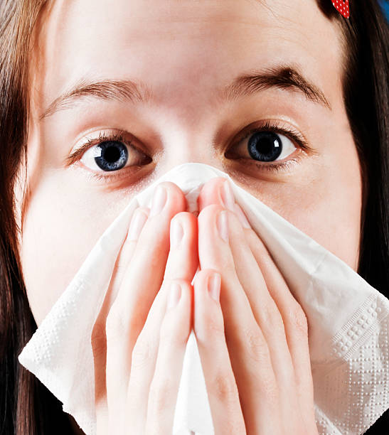 istock Sneezing or crying? Pretty brunette holds kleenex to nose 184313804