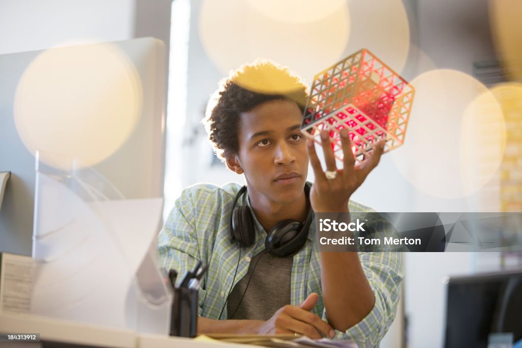 Businessman examining cube at desk in office  Innovation Stock Photo