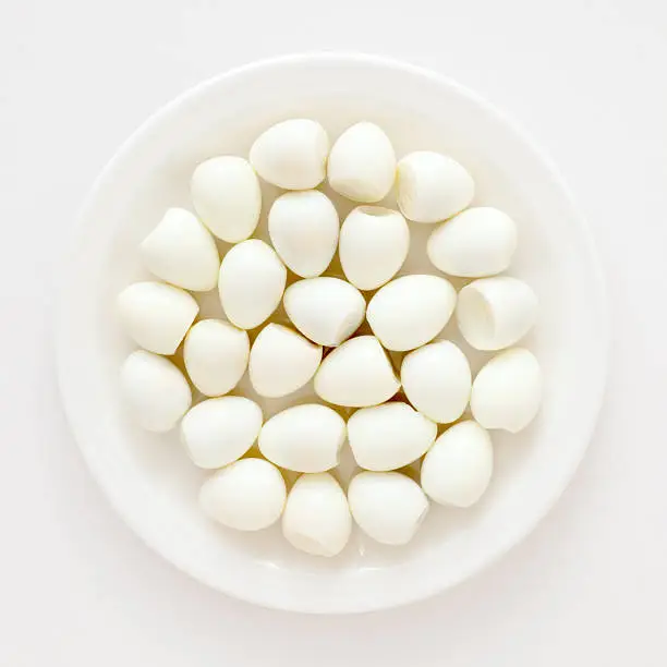 Top view of white dish with lots of boiled quail eggs