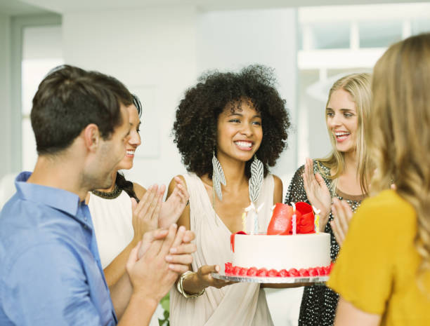 istock Friends clapping around woman with birthday cake 184314352