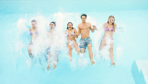 istock Friends jumping into swimming pool 184314415