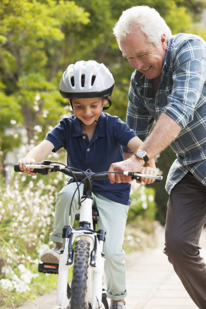 großvater mit enkel trainer, fahrrad - grandfather grandson active seniors senior adult stock-fotos und bilder