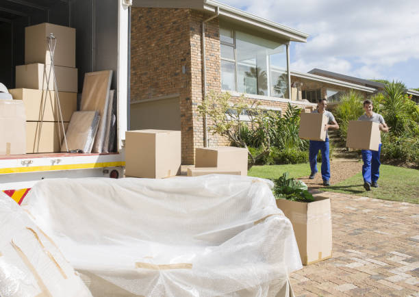 istock Movers carrying cardboard boxes from house to moving van 184314517